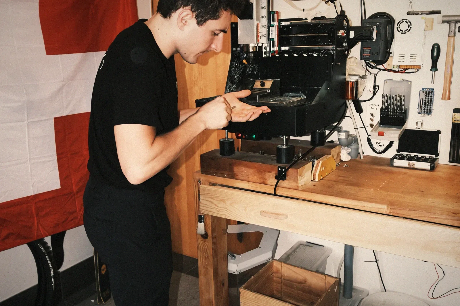 Milling a part on the bench, Swiss flag on the wall